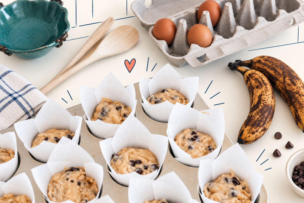 Moules à muffins remplis de pâte aux bananes et pépites de chocolat, prêts à être enfournés.